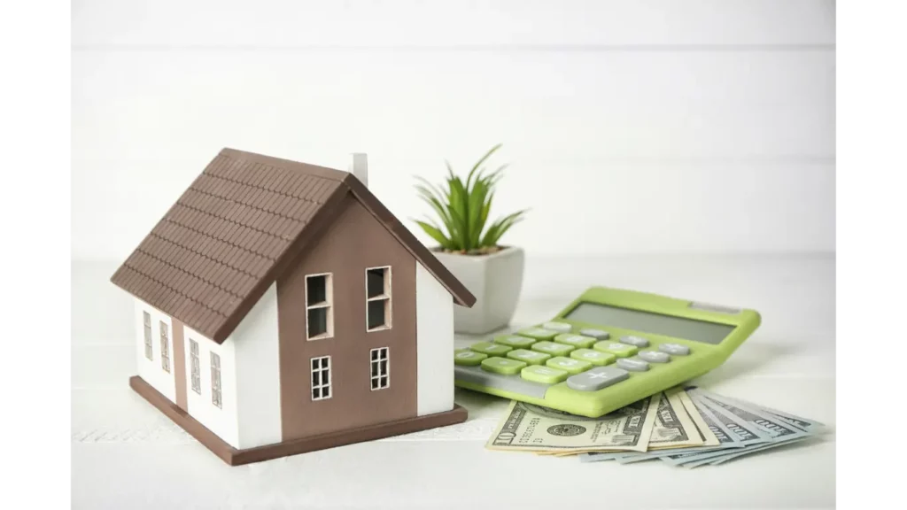 Model house on a table with a calculator and money