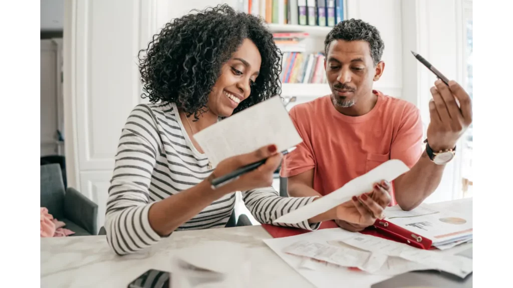 Couple sitting at a table reviewing receipts and documents