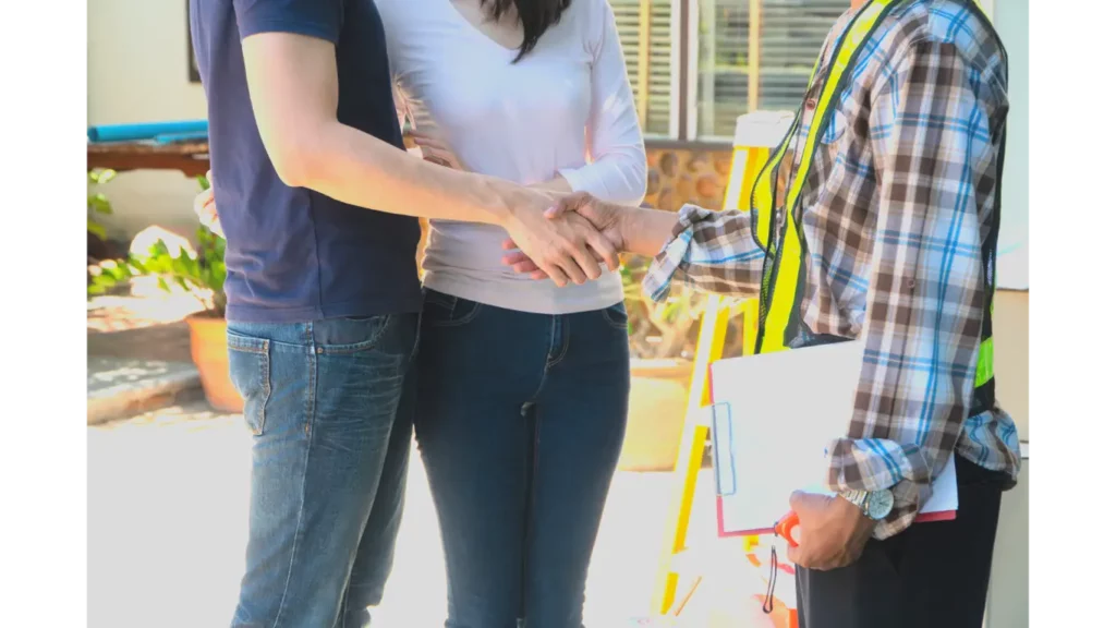 Couple standing in backyard shaking hands with contractor